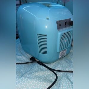 A teal mini fridge that will keep your drinks cold for a while!